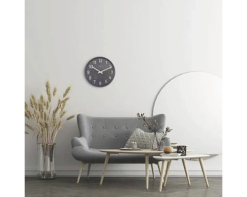 Vardagsrum med grå soffa, soffbord, väggklocka och dekoration