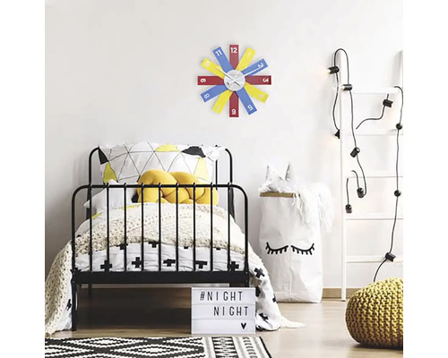 Ett barnrum med en säng, en stege med ljus och en färgglad väggklocka