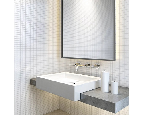 Modernt badrum med vitt tvättställ, spegel och armatur