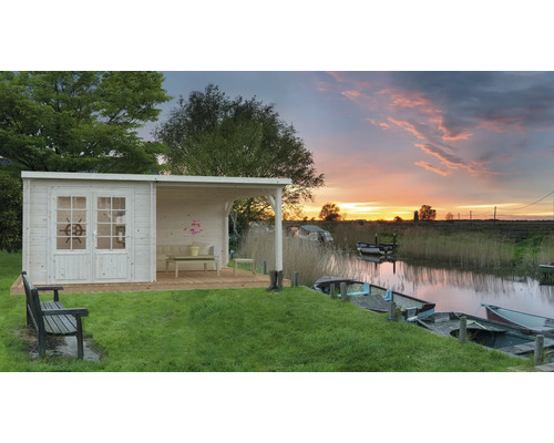 Trädgårdshus i trä med täckt uteplats vid vattnet med båtar