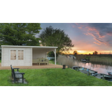 Trädgårdshus med täckt terrass vid en sjöstrand i solnedgången