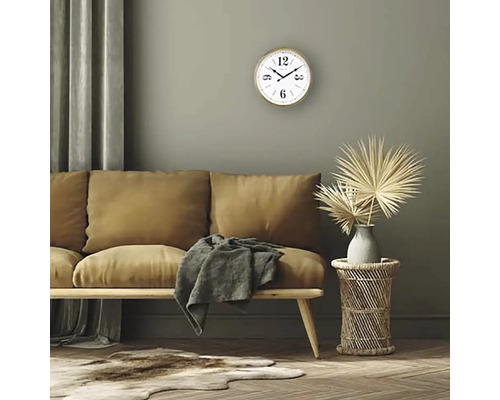 Vardagsrum med soffa, träbord, väggklocka och dekorationer.