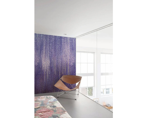 Sovrum med lila blommönstrad tapet och läderfåtölj