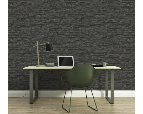 Kontor med stenvägg, skrivbord, lampa, bärbar dator och stol