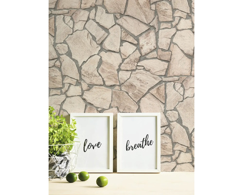 Vägg med stenmönster och två fotoramar med inskriptionerna kärlek och andas.