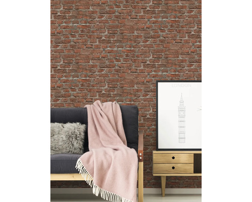 Vardagsrum med tegelvägg, soffa, kudde, filt, sidobord och London-affisch