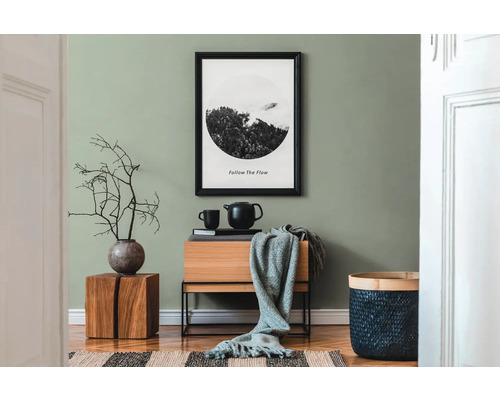 Vardagsrum med trämöbler, dekoration och inramad bild på väggen