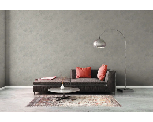 Vardagsrum med grå väggtapet, soffa, golvlampa och matta