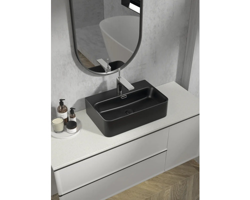 Modernt badrum med svart tvättställsskål, blandare och spegel