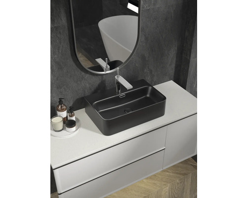 Modernt badrum med svart tvättställsskål, vitt tvättställsskåp och spegel