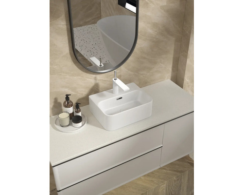 Modernt badrum med handfat, spegel och toalettartiklar på tvättstället