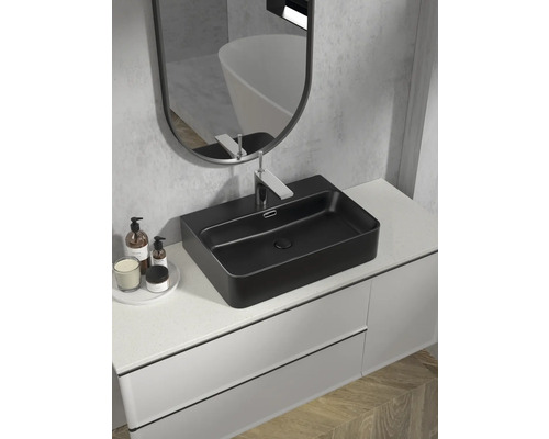 Modernt badrum med svart tvättställsskål, blandare och spegel