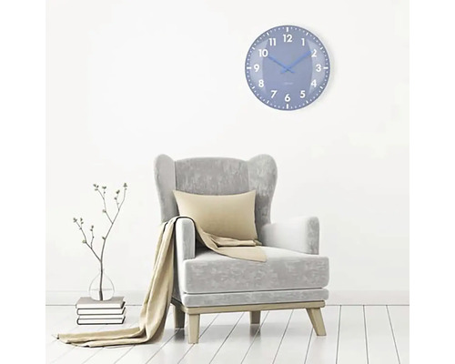 Vardagsrum med fåtölj och blå väggklocka