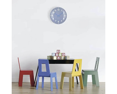 Scen med bord, fyra stolar och väggklocka
