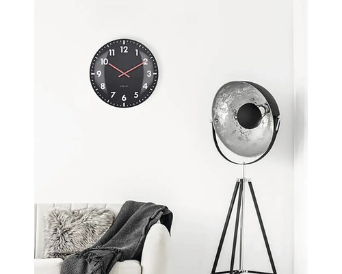 Vardagsrum med väggklocka, golvlampa och soffa