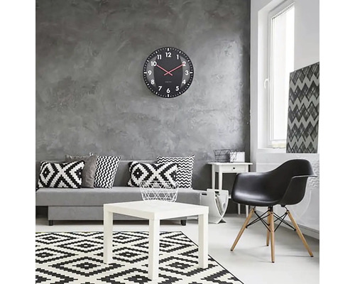 Vardagsrum med soffa, bord, stol, matta och väggklocka