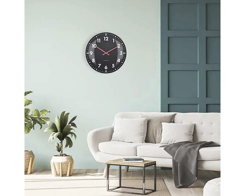 Vardagsrum med väggklocka, soffa och sidobord