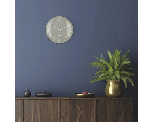 Vardagsrum med väggklocka, krukväxt och träskänk