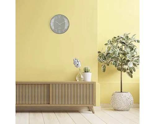 Vardagsrum med skänk, krukväxter och en väggklocka