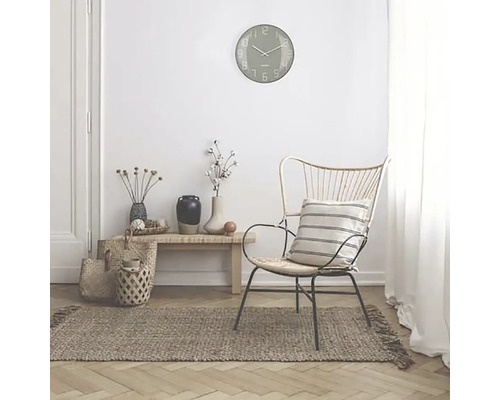 Interiörscen med en väggklocka, en stol, en matta och dekorativa tillbehör för en mysig atmosfär