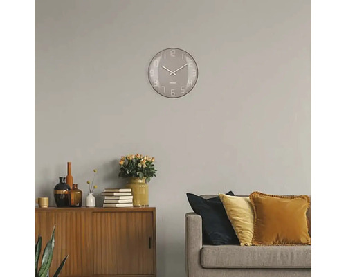 Vardagsrum med väggklocka, byrå och soffa