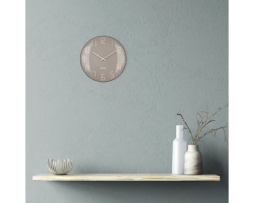 Väggklocka med urtavla på en hylla med dekorativa föremål