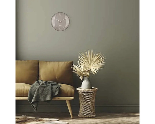 Vardagsrum med soffa, sidobord, dekoration och rund väggklocka