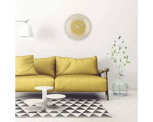 Vardagsrum med gul soffa, soffbord, matta och rund väggklocka