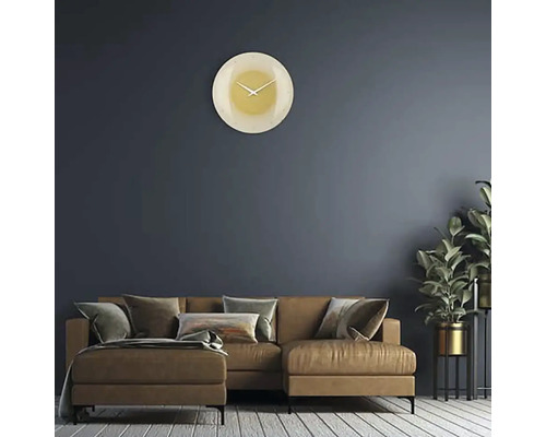 Vardagsrum med soffa, krukväxt och rund väggklocka