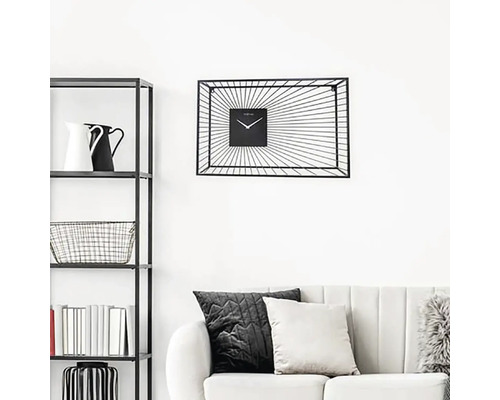 Vardagsrum med hylla, soffa och svart väggklocka