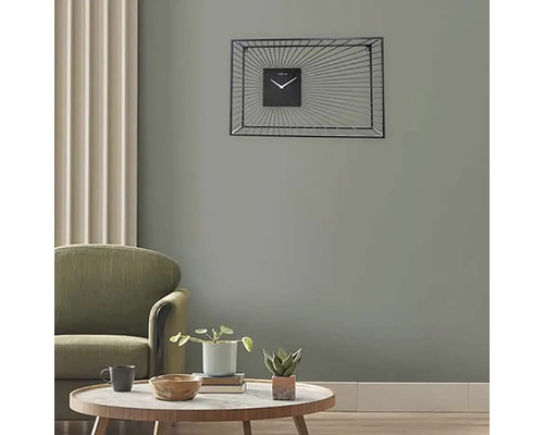 Vardagsrum med fåtölj, bord och rektangulär väggklocka