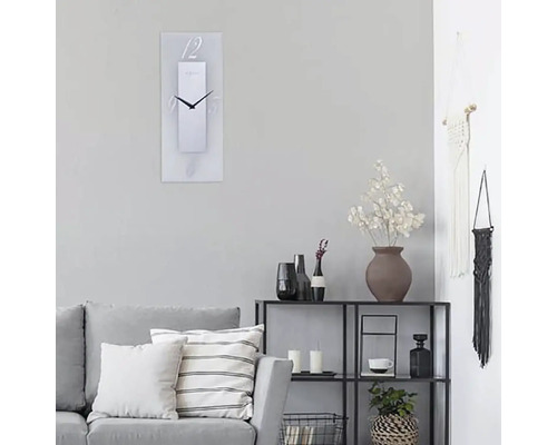 Vardagsrum med soffa, hylla och rektangulär väggklocka med siffror