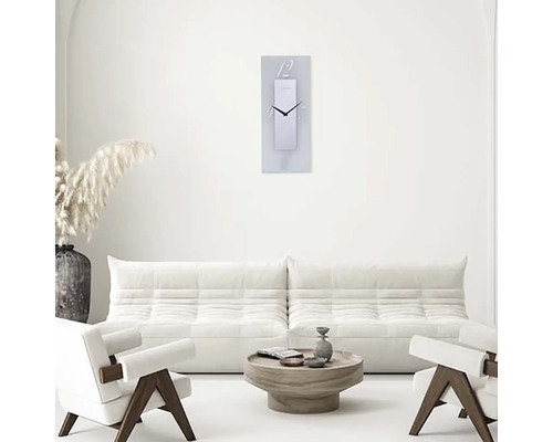 Vardagsrum med soffa, fåtölj, soffbord och rektangulär väggklocka