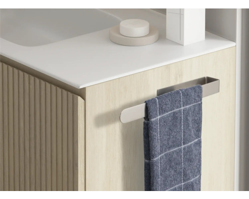 Detaljvy av ett tvättställsskåp med handdukshållare och handduk