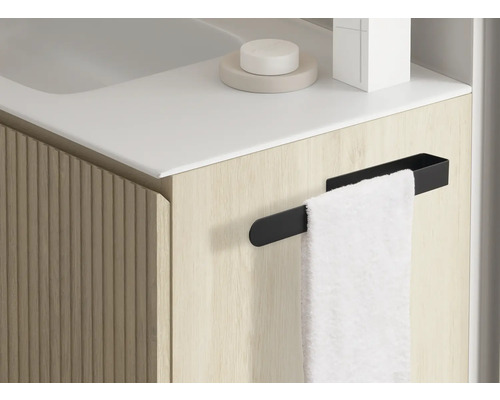 Närbild av ett badrumsskåp med handdukshållare och handduk.