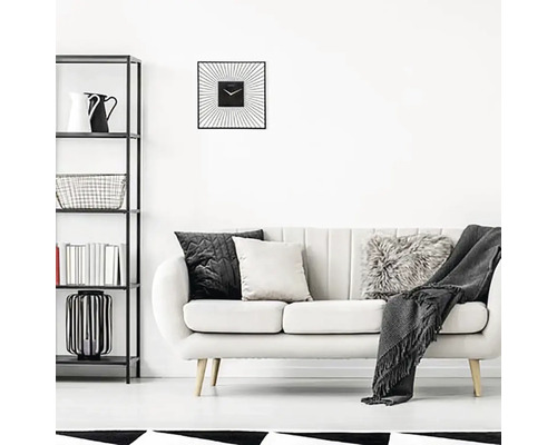 Vardagsrum med hylla, soffa, kuddar och en fyrkantig väggklocka