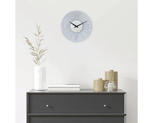 Dekorativ väggklocka ovanför en byrå med hemtillbehör