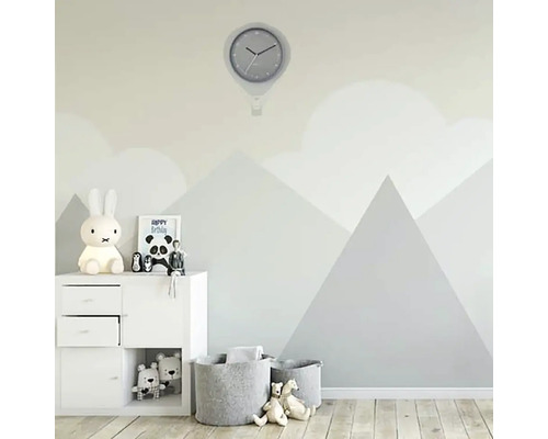 Barnrum med väggklocka, förvaringsmöbler och leksakskorgar framför en vägg med bergmotiv