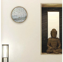 Dekorativ väggdekoration med en väggklocka och en Buddha-staty.