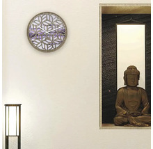 Väggdekoration med en klocka och en Buddha-staty i en hylla