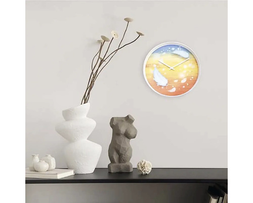 Dekorativ scen med väggklocka, vas, växt och skulptur på en hylla.