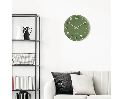 Väggklocka i vardagsrum med hylla och soffa.
