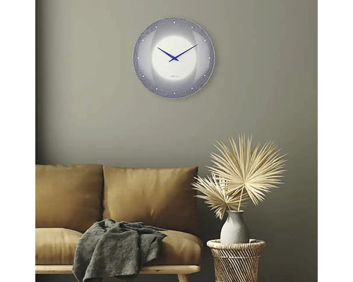 Vardagsrum med soffa, sidobord med dekoration och rund väggklocka