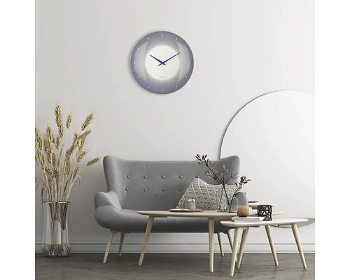 Vardagsrum med grå soffa, träbord och rund väggklocka