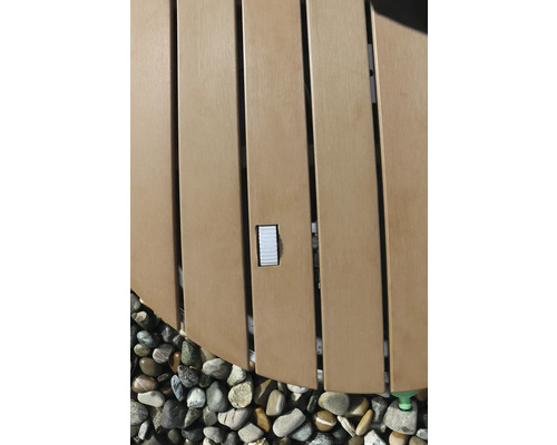 Detalj av en bubbelpool med träpanel och stenar.