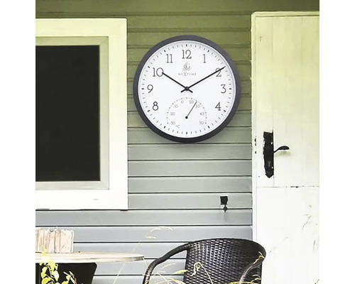 Analog väggklocka med termometer för utomhusbruk på husvägg