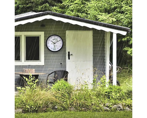 Trädgårdshus med bord, stol och klocka i regnet