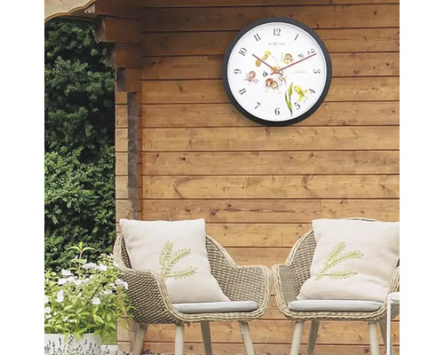Trädgårdsscen med väggklocka, stolar och kuddar