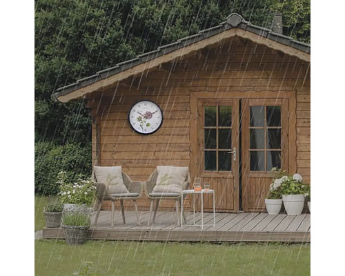 Trädgårdshus med väggklocka i regnet, stolar och bord