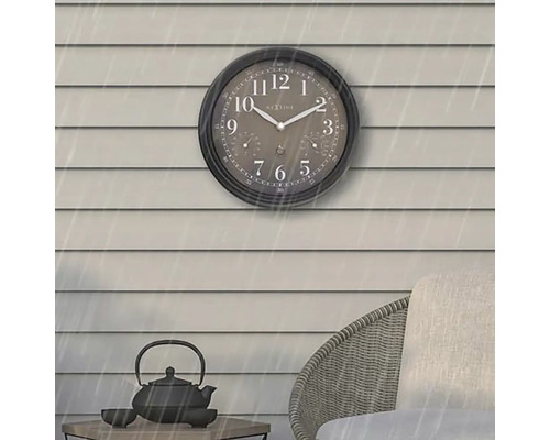 Analog utomhusklocka med termometer- och hygrometerdisplay på en husvägg